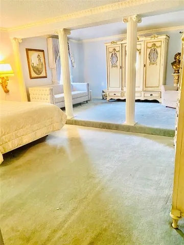 a spacious bedroom with a bed and painting on the wall