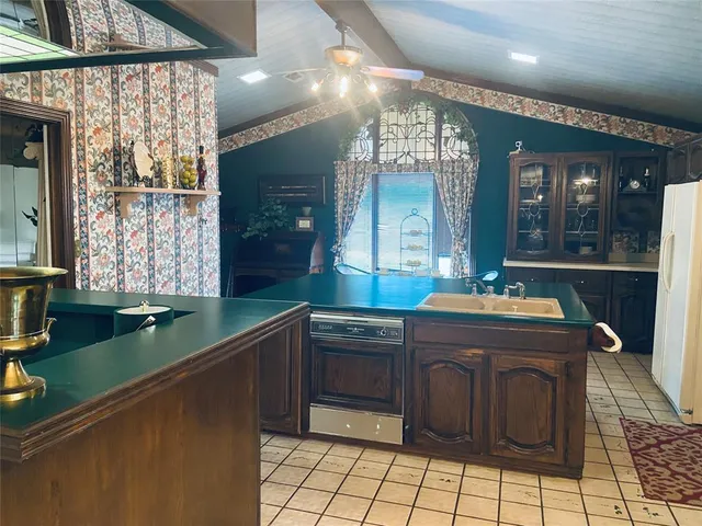 a kitchen with kitchen island granite countertop a sink and a stove
