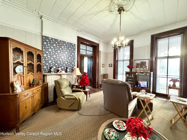 a living room with patio furniture and a chandelier