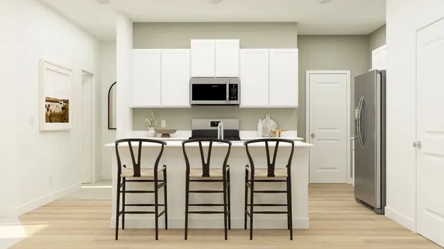 a kitchen with stainless steel appliances a microwave a sink and white cabinets