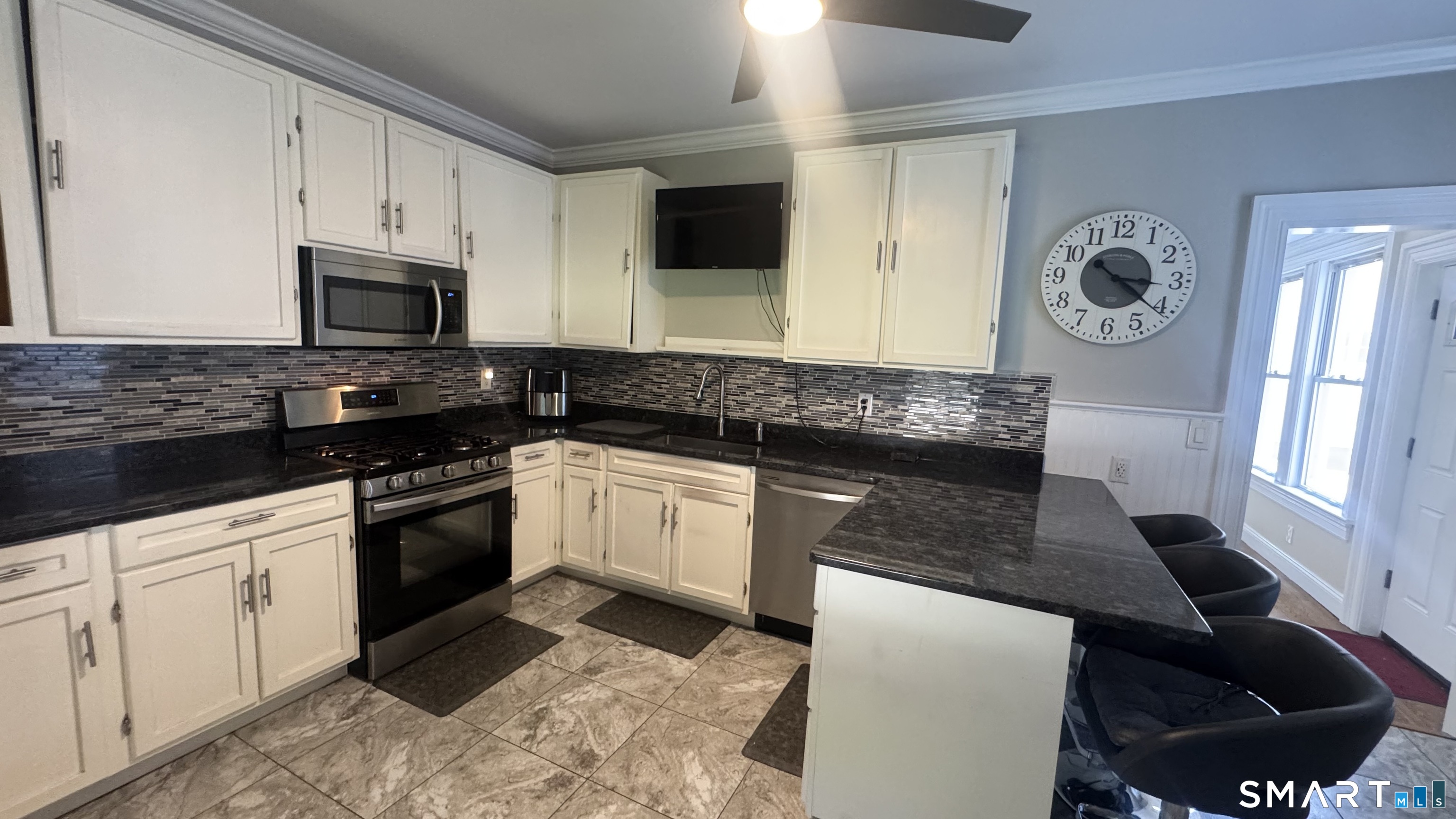 104 Prospect Street Ansonia, CT 06401 - Photo 15 of 40 a kitchen with granite countertop a sink a stove and cabinets