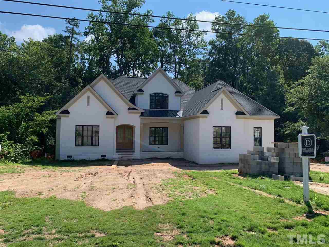 a view of a yard in front of a house with large trees