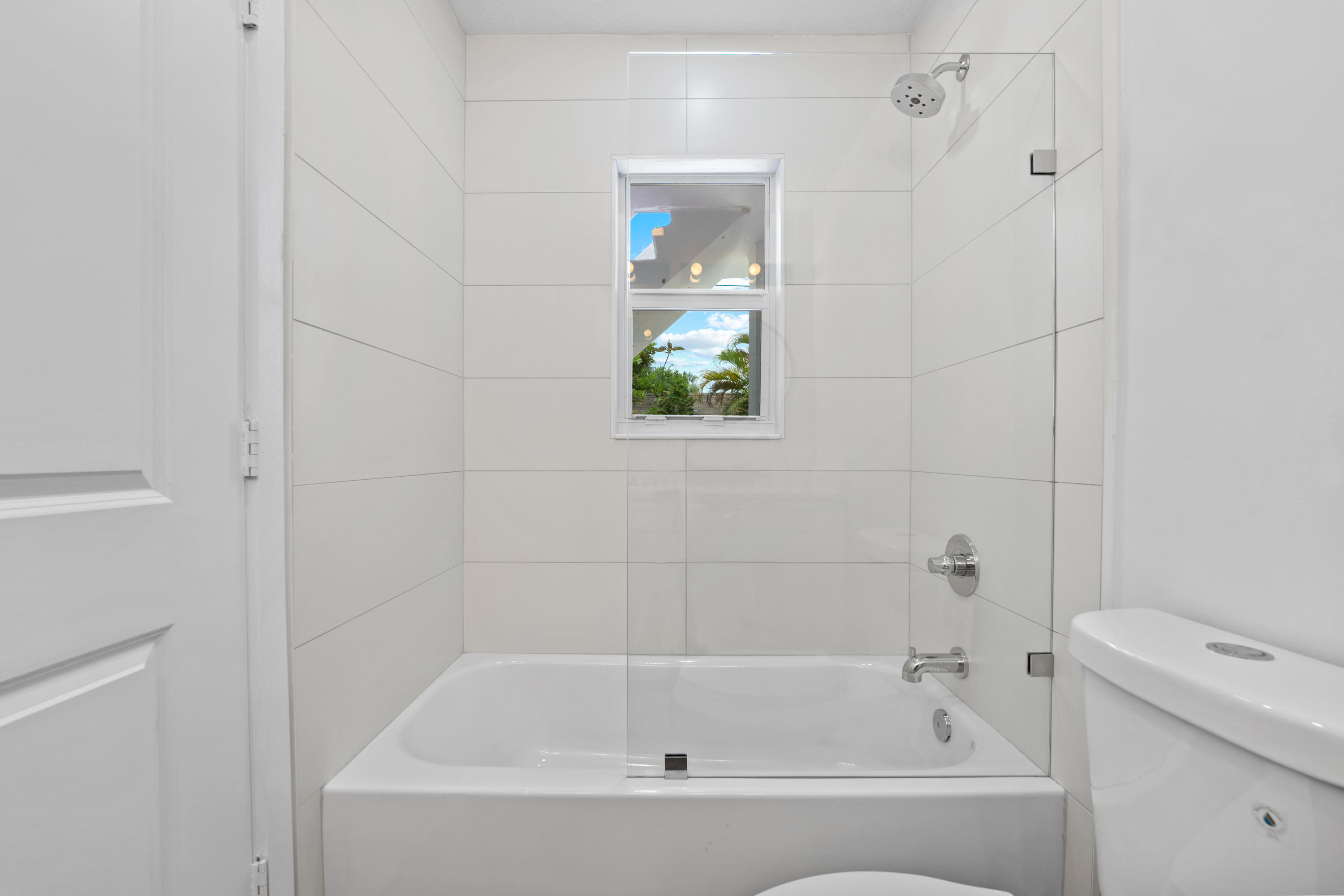1279 Beach Road, Unit 2 Singer Island, FL 33404 - Photo 12 of 20 a white bath tub with a window