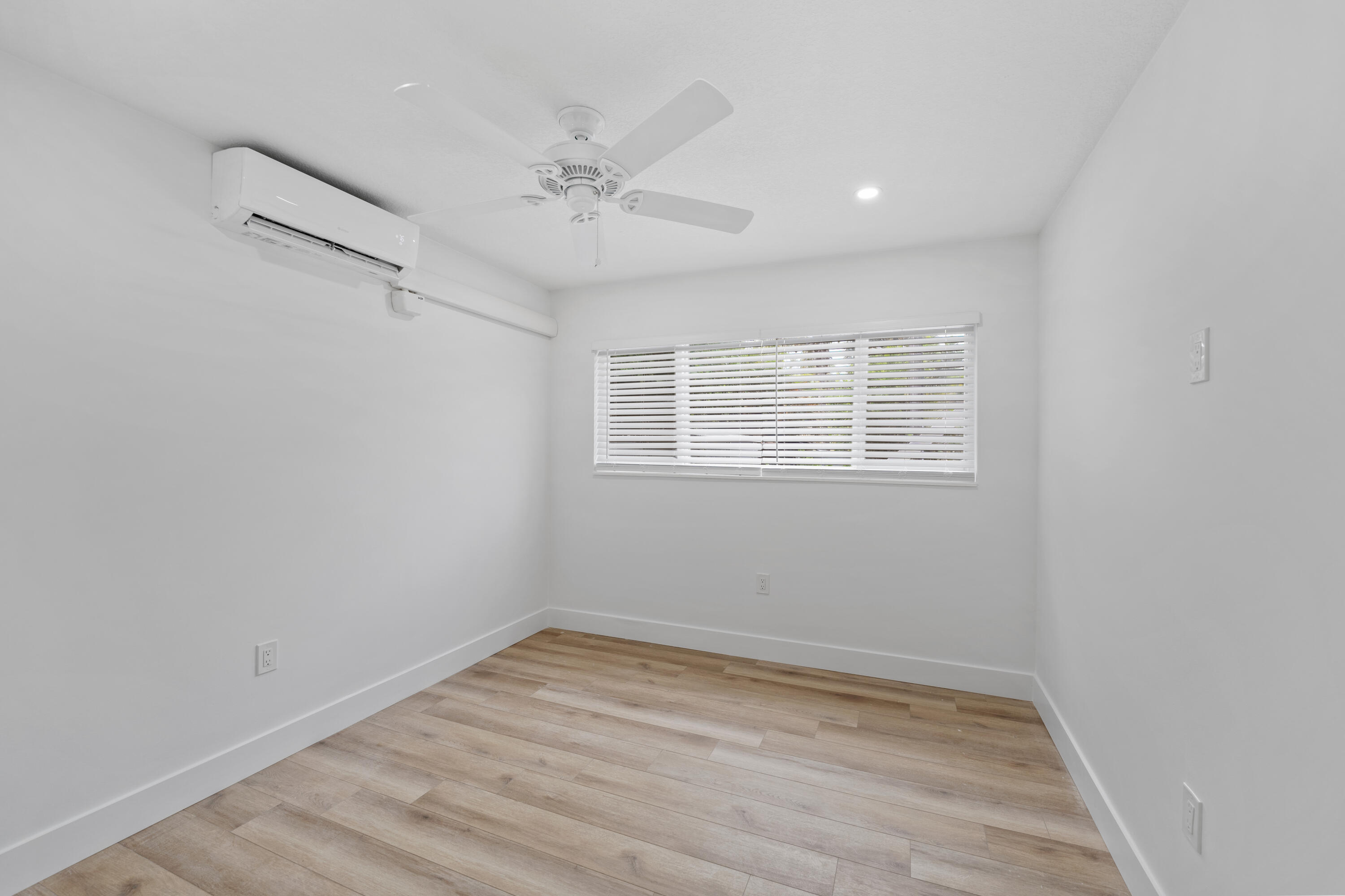 1279 Beach Road, Unit 2 Singer Island, FL 33404 - Photo 13 of 20 a view of an empty room with wooden floor and a window