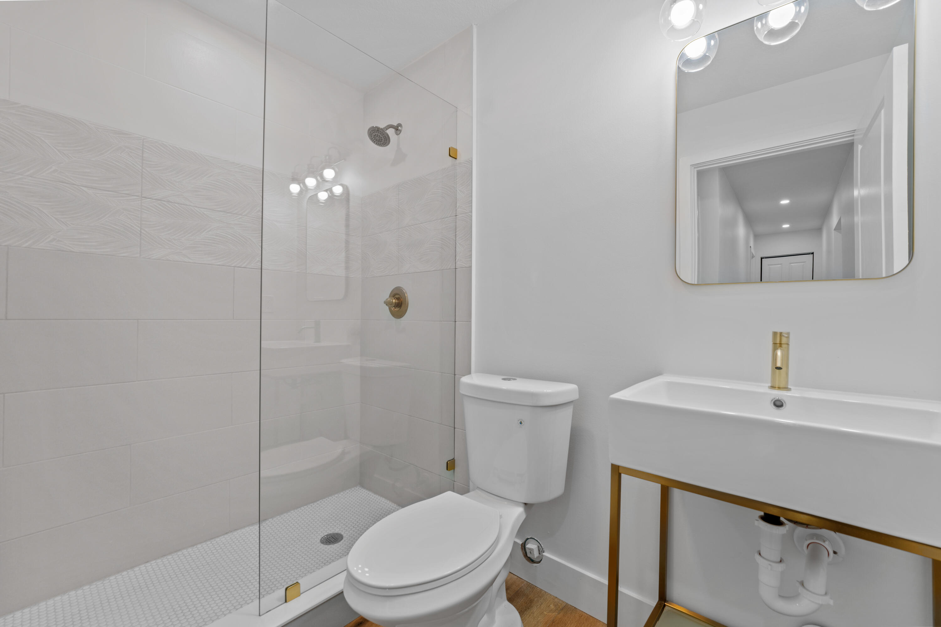 1279 Beach Road, Unit 2 Singer Island, FL 33404 - Photo 14 of 20 a white toilet sitting next to a bathroom sink