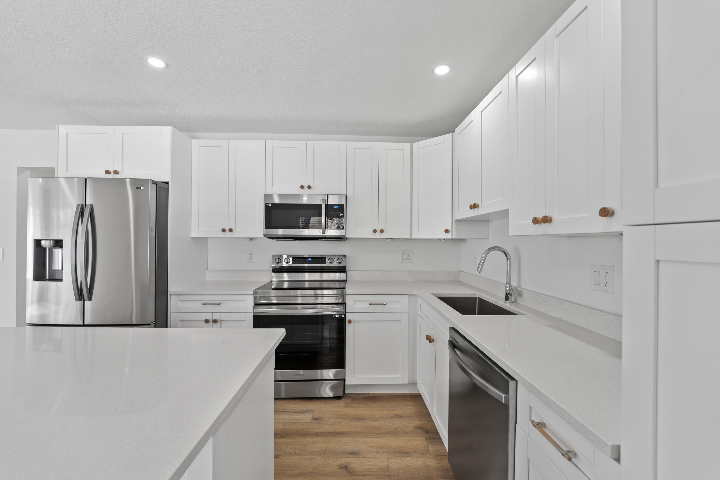 1279 Beach Road, Unit 2 Singer Island, FL 33404 - Photo 8 of 20 a kitchen with stainless steel appliances a sink stove refrigerator and cabinets