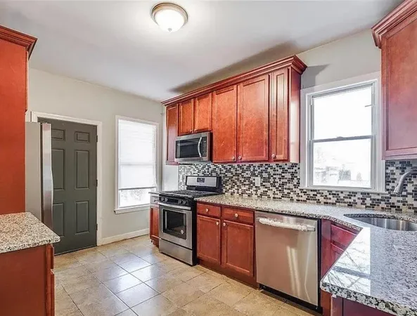 a kitchen with stainless steel appliances granite countertop a stove a sink and a microwave