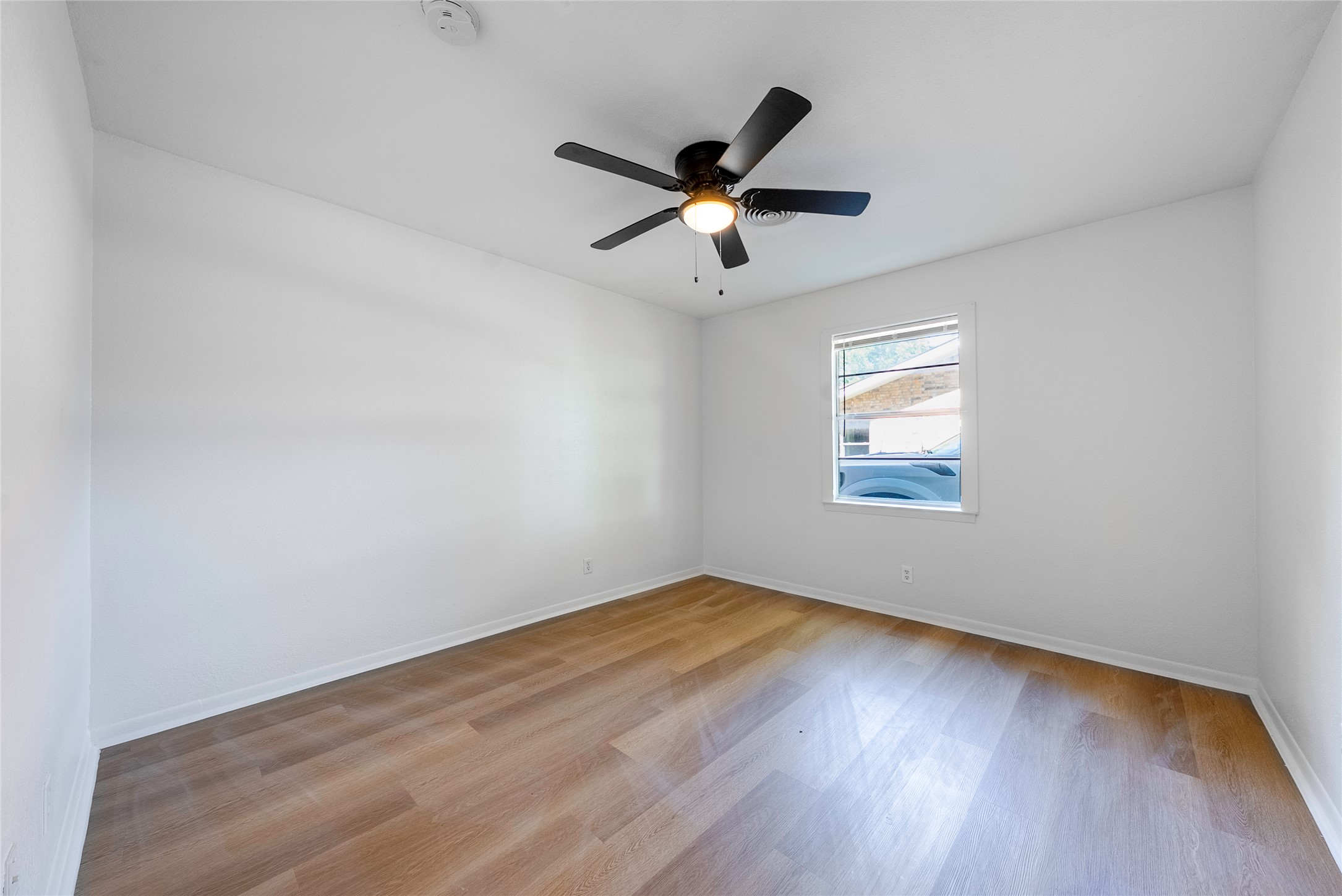 807 Country Club Road Georgetown, TX 78628 - Photo 21 of 28 an empty room with wooden floor fan and windows