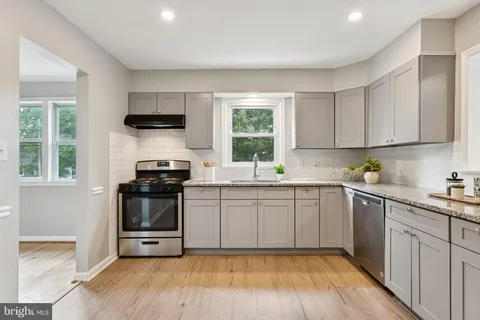 a kitchen with a sink stove top oven and refrigerator