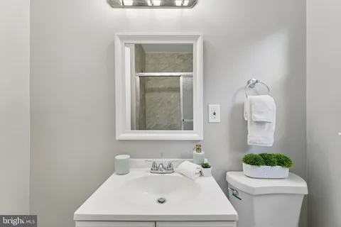 a bathroom with a sink mirror and toilet