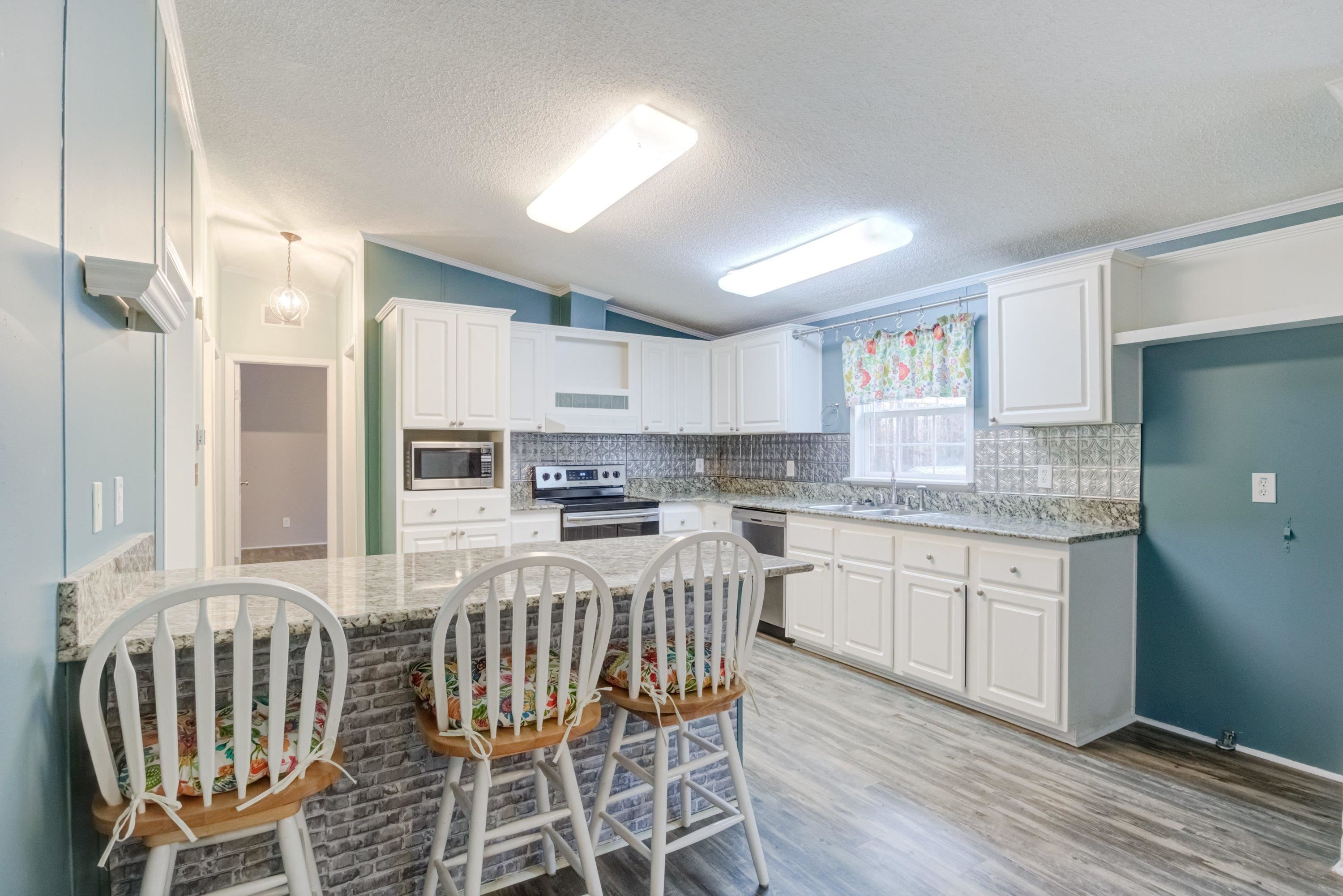 32 Red Oak Drive Smithfield, NC 27577 - Photo 14 of 47 a kitchen with stainless steel appliances granite countertop a white cabinets and a stove top oven