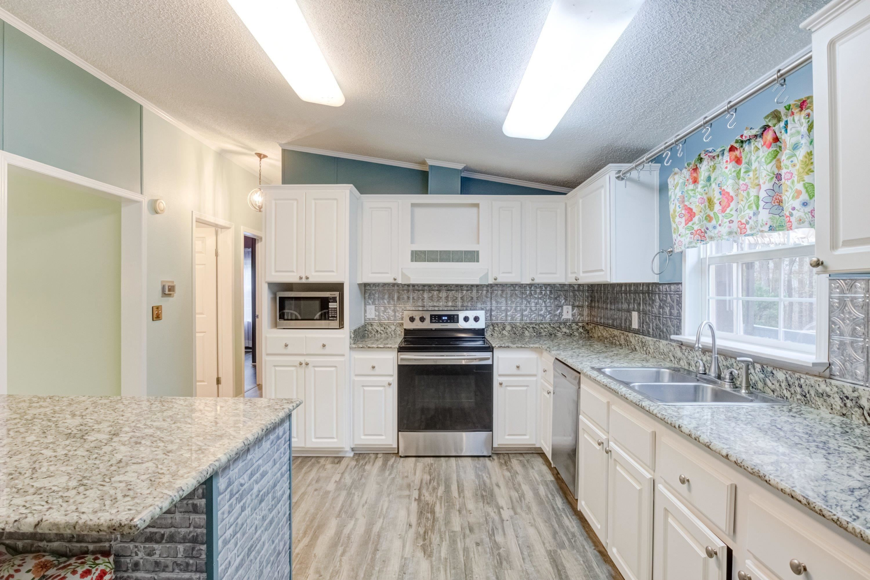 32 Red Oak Drive Smithfield, NC 27577 - Photo 15 of 47 a kitchen with stainless steel appliances granite countertop a stove and a sink