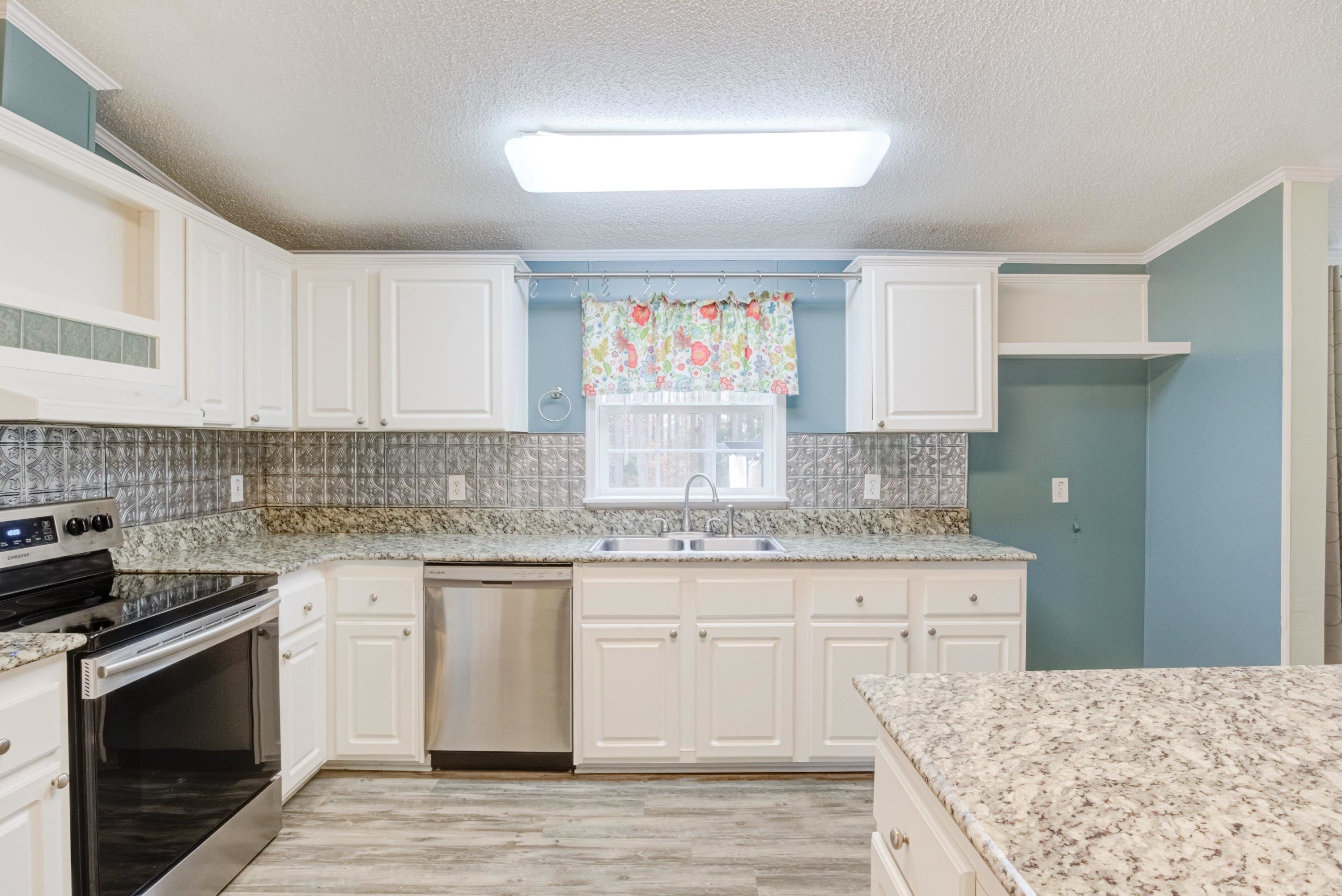 32 Red Oak Drive Smithfield, NC 27577 - Photo 17 of 47 a kitchen with granite countertop a sink stove and cabinets