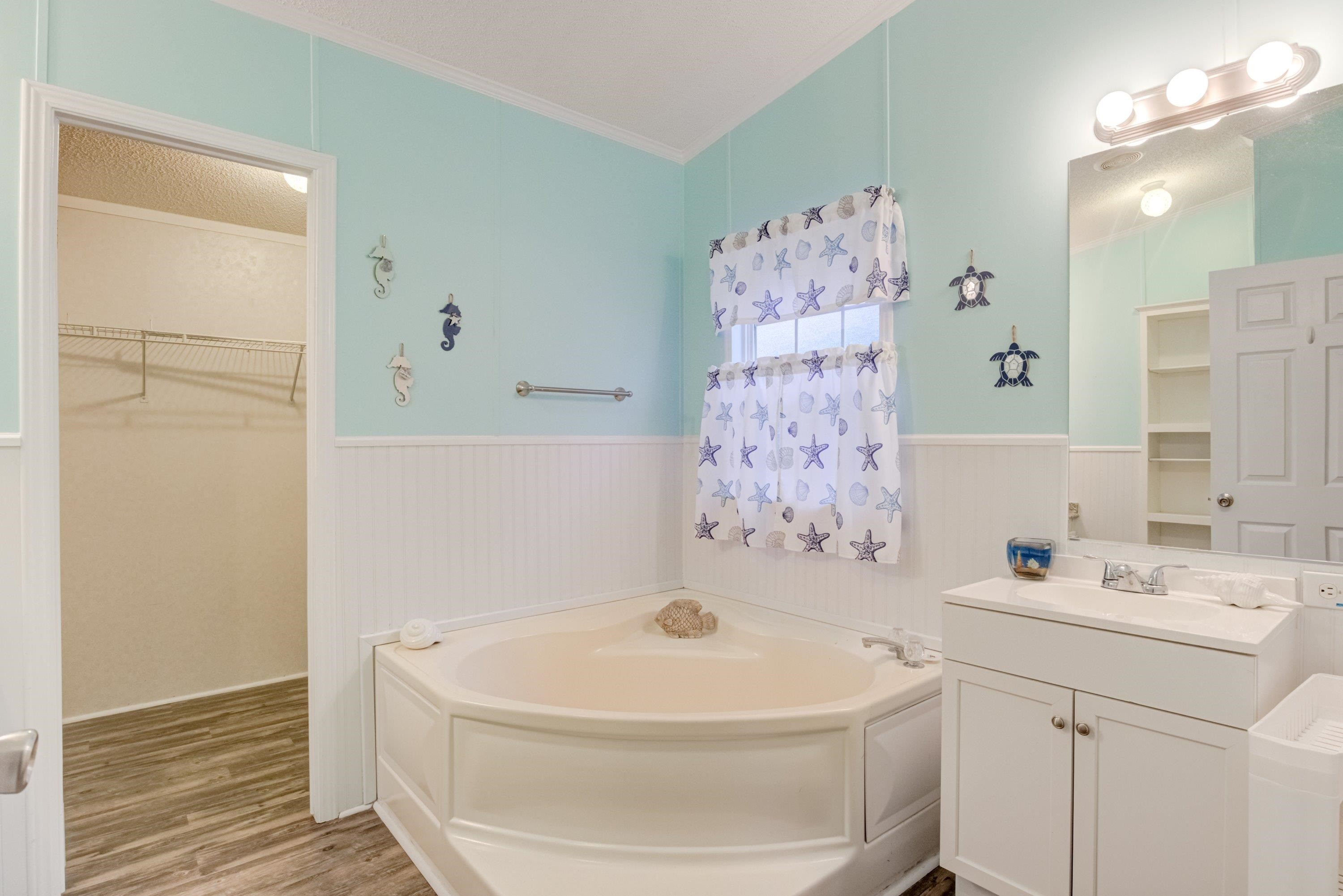 32 Red Oak Drive Smithfield, NC 27577 - Photo 23 of 47 a bathroom with a white bath tub a sink and a mirror