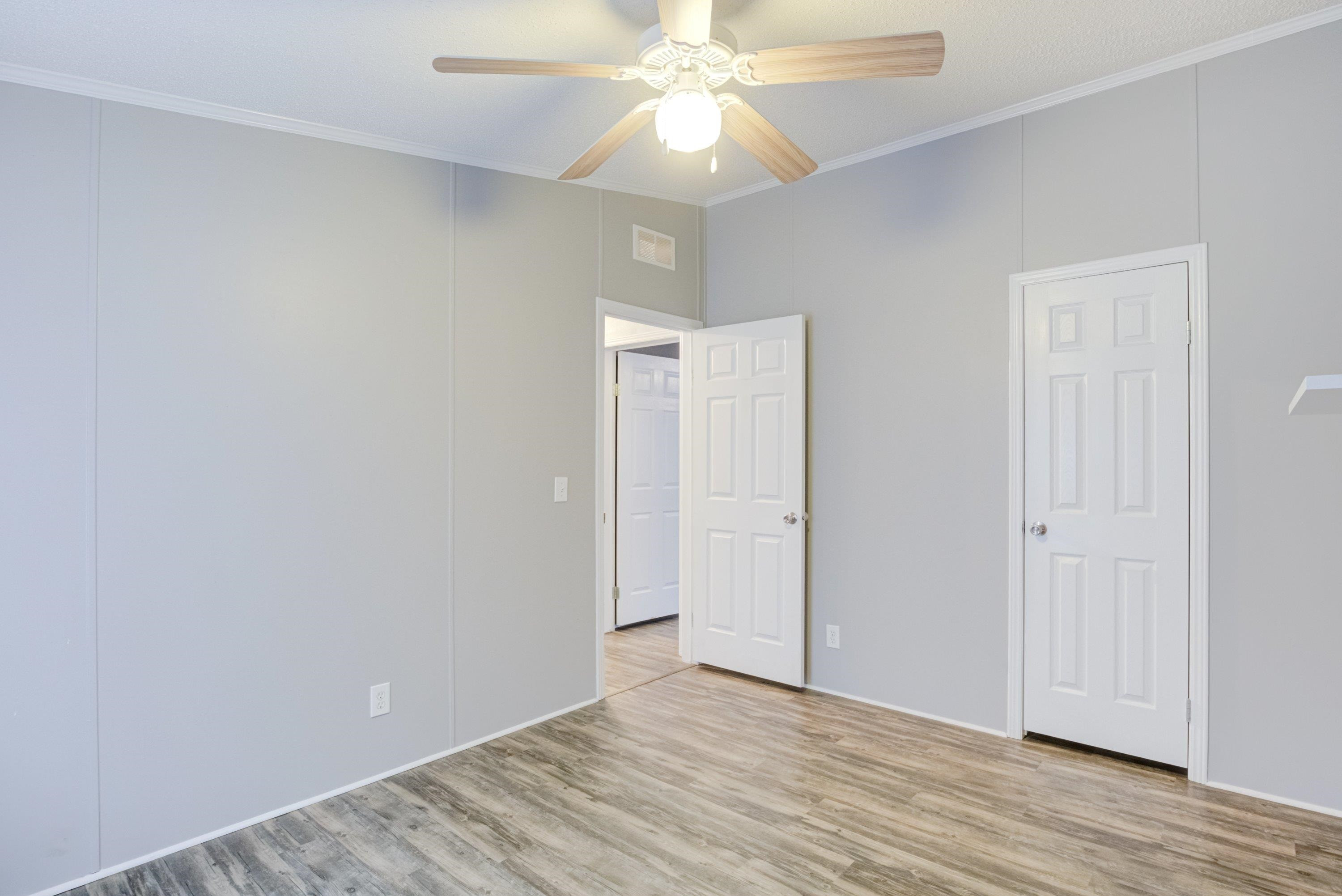 32 Red Oak Drive Smithfield, NC 27577 - Photo 32 of 47 a view of an empty room with wooden floor and a ceiling fan