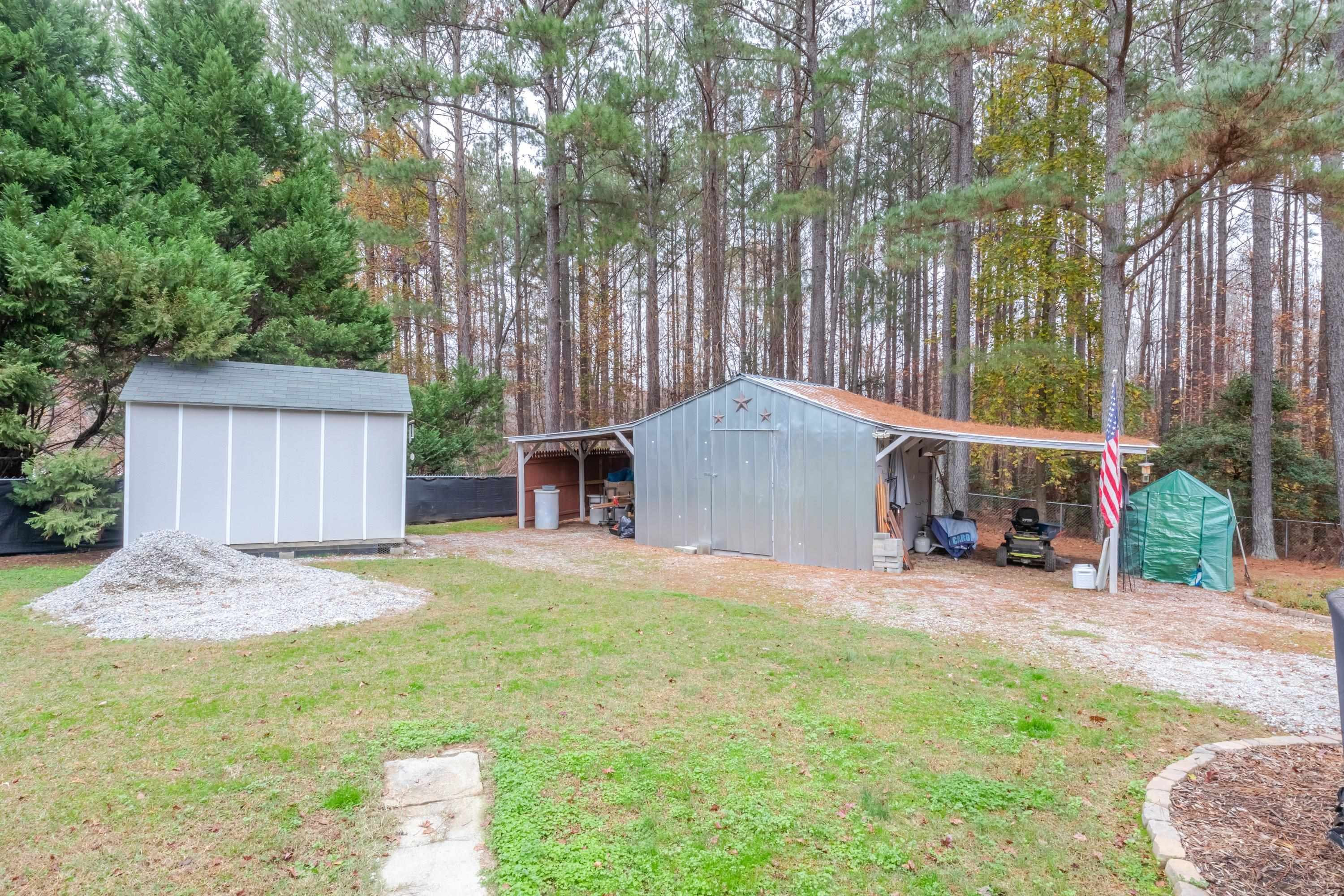 32 Red Oak Drive Smithfield, NC 27577 - Photo 45 of 47 a backyard of a house with table and chairs wooden fence and a large tree