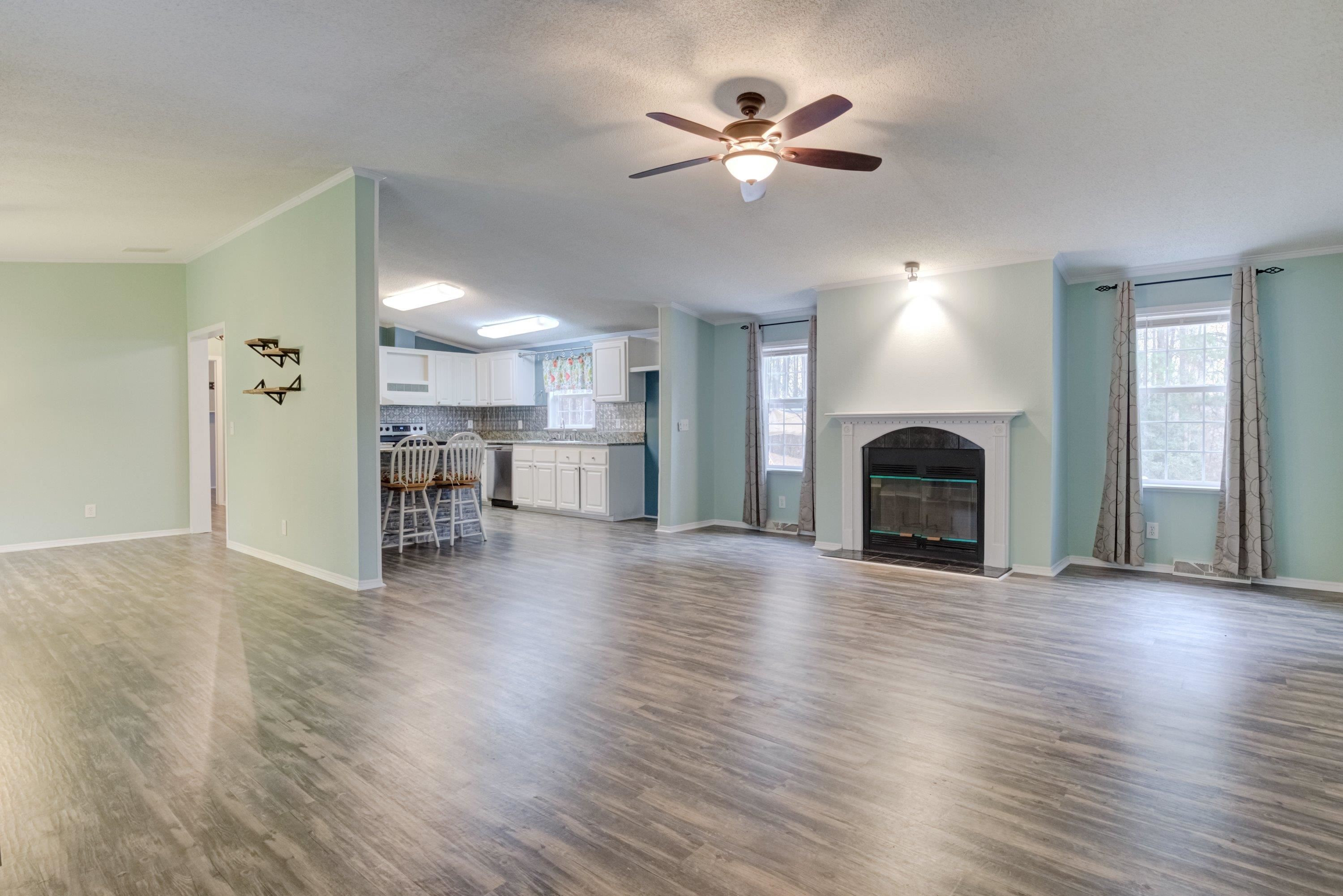 32 Red Oak Drive Smithfield, NC 27577 - Photo 6 of 47 a view of a livingroom with a fireplace a chandelier and wooden floor