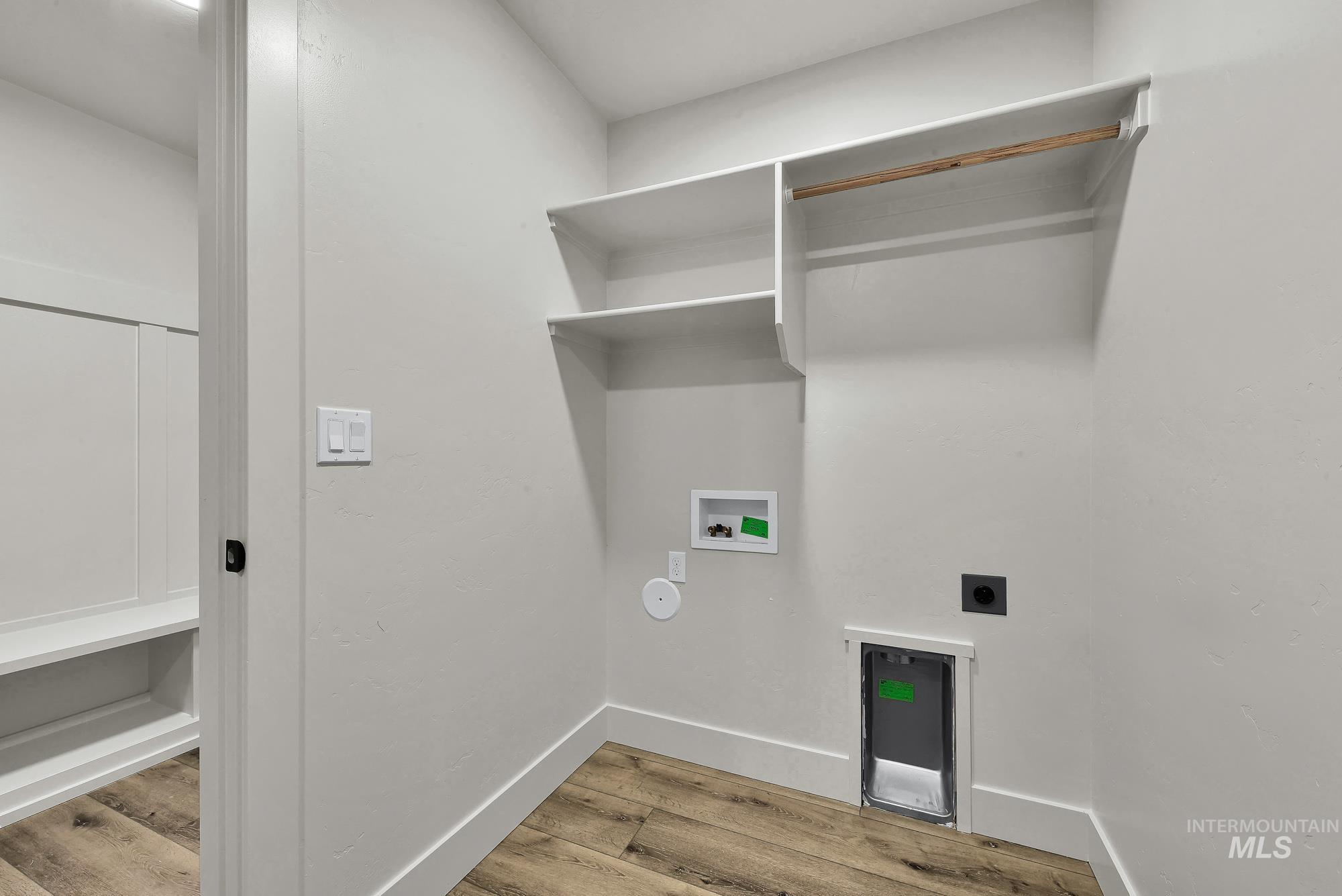1130 Velvet Loop Wilder, ID 83676 - Photo 35 of 35 Dedicated utility room featuring wood-finish flooring, built-in shelving, a clothes rod, and white baseboards