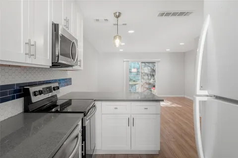 a kitchen with stainless steel appliances granite countertop a sink and a stove