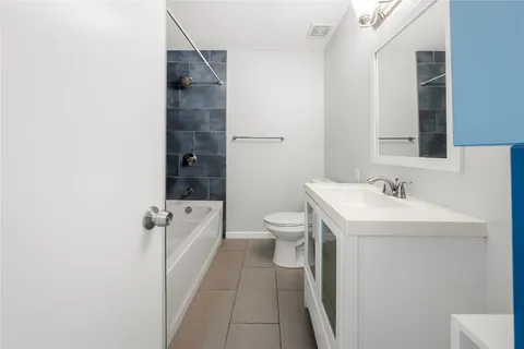 a spacious bathroom with a sink a toilet a shower and a mirror