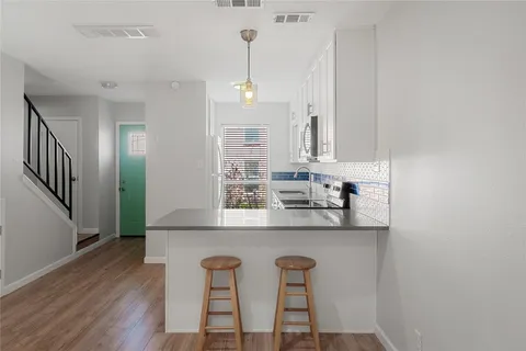 a kitchen with stainless steel appliances granite countertop a sink and a refrigerator