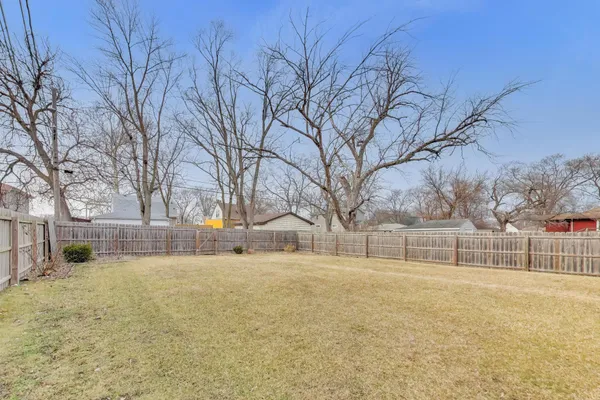 a view of a yard with trees in the background
