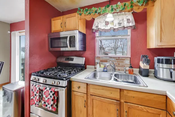 a kitchen with stainless steel appliances granite countertop a stove a sink and a microwave