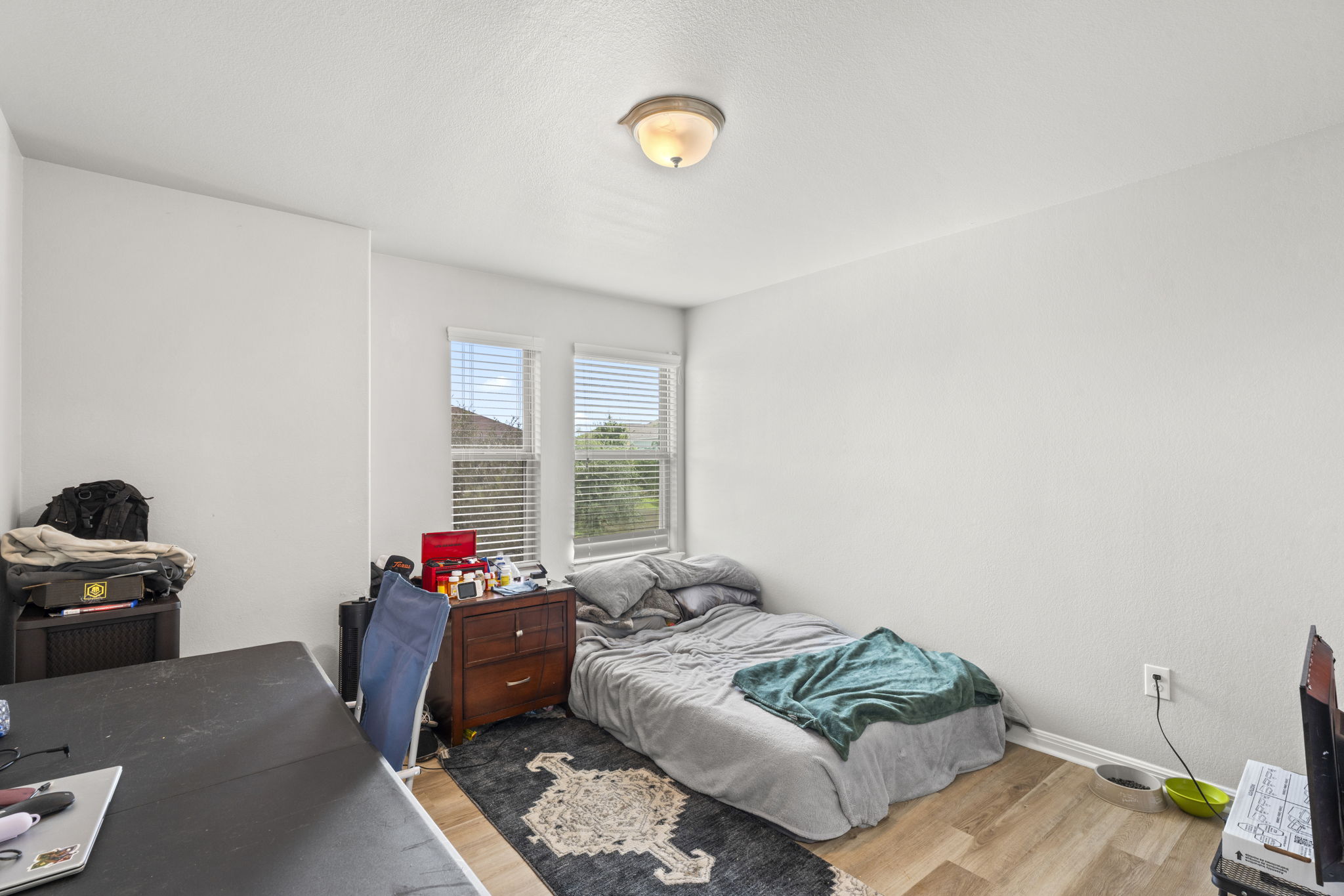 424 Wapiti Road Buda, TX 78610 - Photo 12 of 21 A well-lit bedroom features durable hardwood flooring and natural illumination through dual windows.