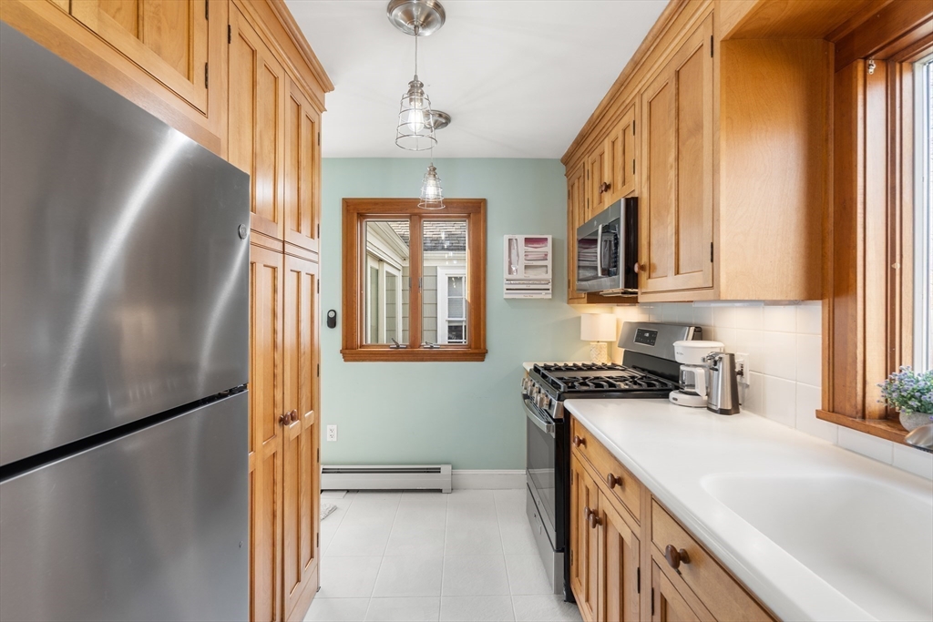 38 Carlton Road Marblehead, MA 01945 - Photo 15 of 36 a kitchen with stainless steel appliances granite countertop a refrigerator a sink dishwasher a stove and a dining table with wooden floor