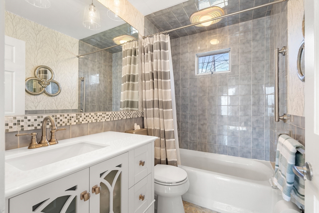 38 Carlton Road Marblehead, MA 01945 - Photo 19 of 36 a bathroom with a sink a toilet a mirror a bathtub and shower