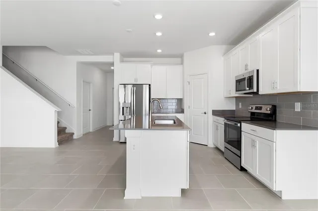 a view of kitchen with stainless steel appliances refrigerator sink and microwave