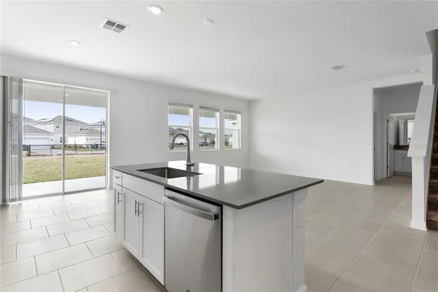 a kitchen with stainless steel appliances a refrigerator a stove a microwave and white cabinets