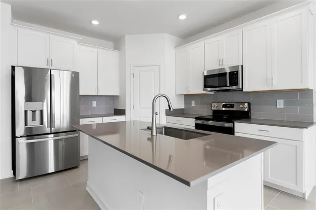 a kitchen with stainless steel appliances granite countertop a refrigerator oven a stove top oven a sink and dishwasher