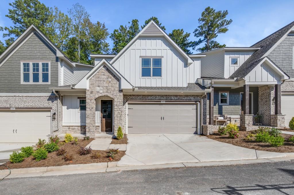 a front view of a house with a garden and potted plants