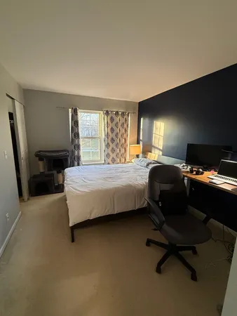 a bedroom with a bed chair and dresser