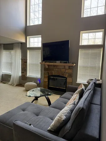 a living room with furniture a flat screen tv and a fireplace