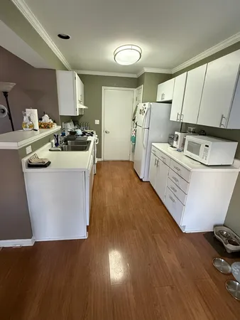 a kitchen with sink cabinets and wooden floor