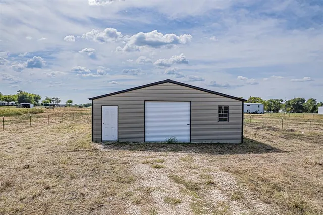 a view of a house with yard and wooden fence