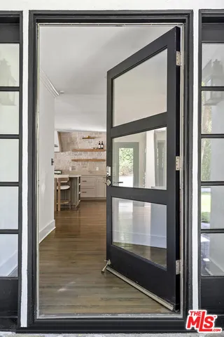 a kitchen with stainless steel appliances granite countertop wooden floor and large window