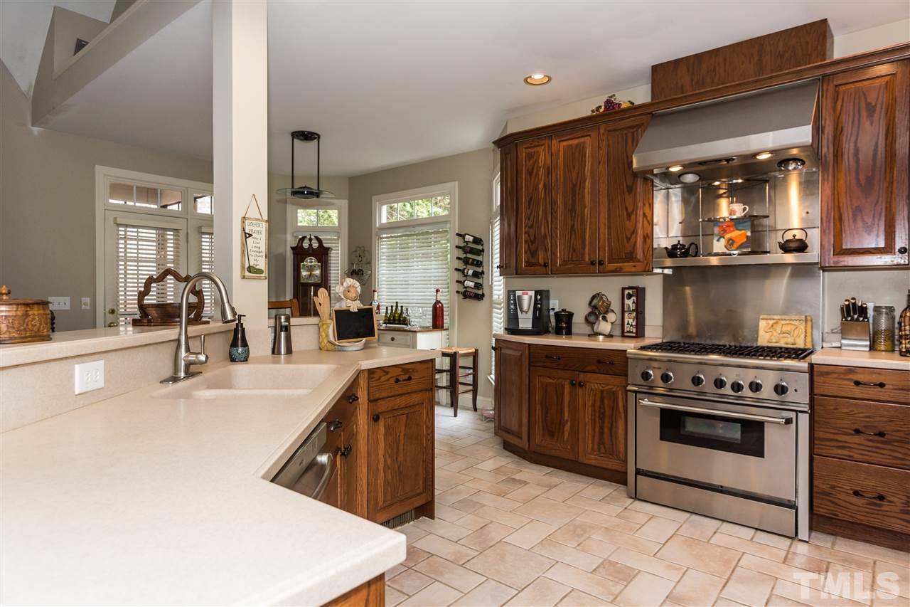 6521 Arbor Grande Way Raleigh, NC 27615 - Photo 5 of 12 a kitchen with stainless steel appliances granite countertop a stove a sink and a microwave