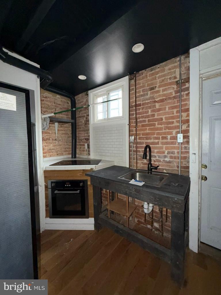 1607 Lemmon Street Baltimore, MD 21223 - Photo 7 of 30 a kitchen with stainless steel appliances a sink stove and cabinets