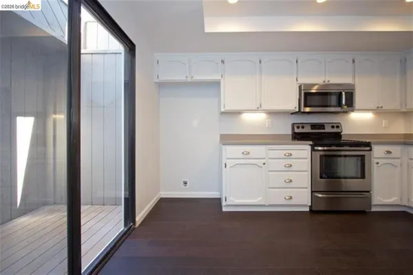a kitchen with white cabinets and stainless steel appliances