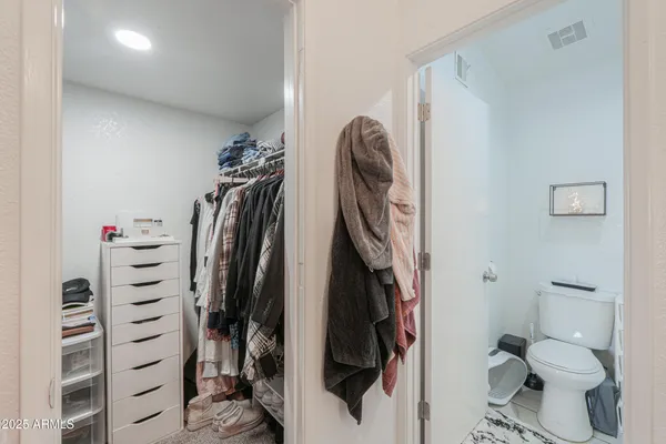 a view of walk in closet with clothes and shoes