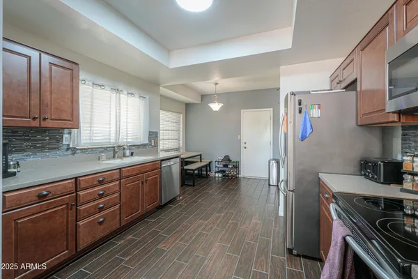a large kitchen with stainless steel appliances granite countertop a lot of counter space and wooden floors