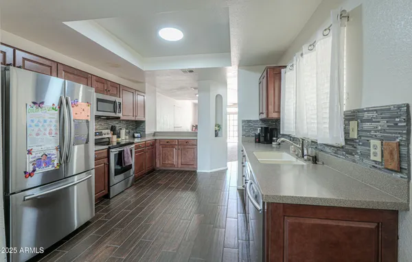 a kitchen with stainless steel appliances a sink a stove and a refrigerator