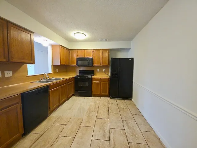 a kitchen with stainless steel appliances granite countertop a refrigerator stove and sink