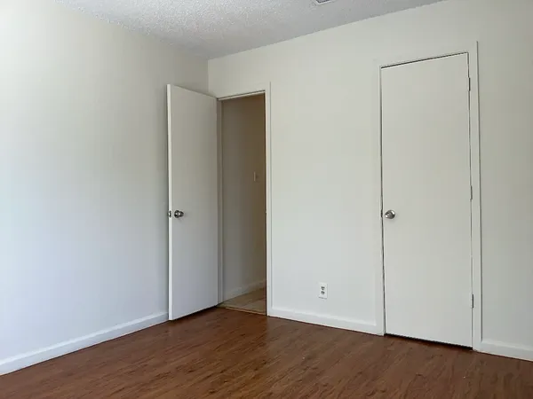a view of an empty room with wooden floor