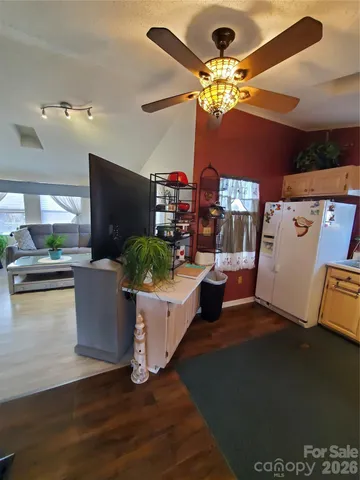 a living room with couches and a dining table with kitchen view