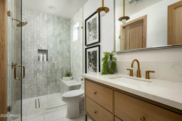 a bathroom with a sink a toilet and a mirror