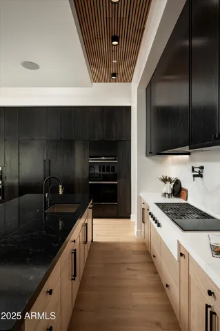 a kitchen with granite countertop a sink and a refrigerator
